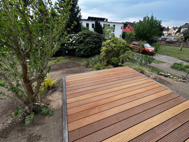 Eine Holzterrasse aus Bankirai mit einer Einfassung aus Beton Tiefborden zum abfangen der Höhenunterschiede